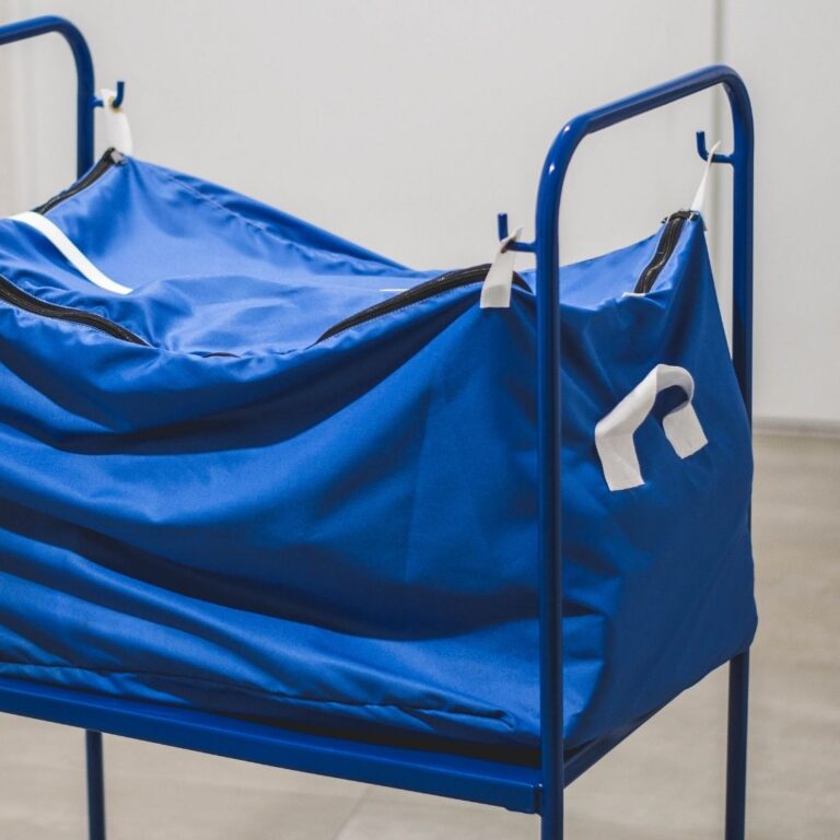 Chariot de transport métallique RTP Radom équipé d'un sac textile bleu refermable par fermeture éclair, utilisé dans la logistique professionnelle de blanchisserie.